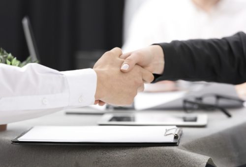 two-businesspeople-shaking-each-other-s-hand-clipboard-desk_23-2148073316